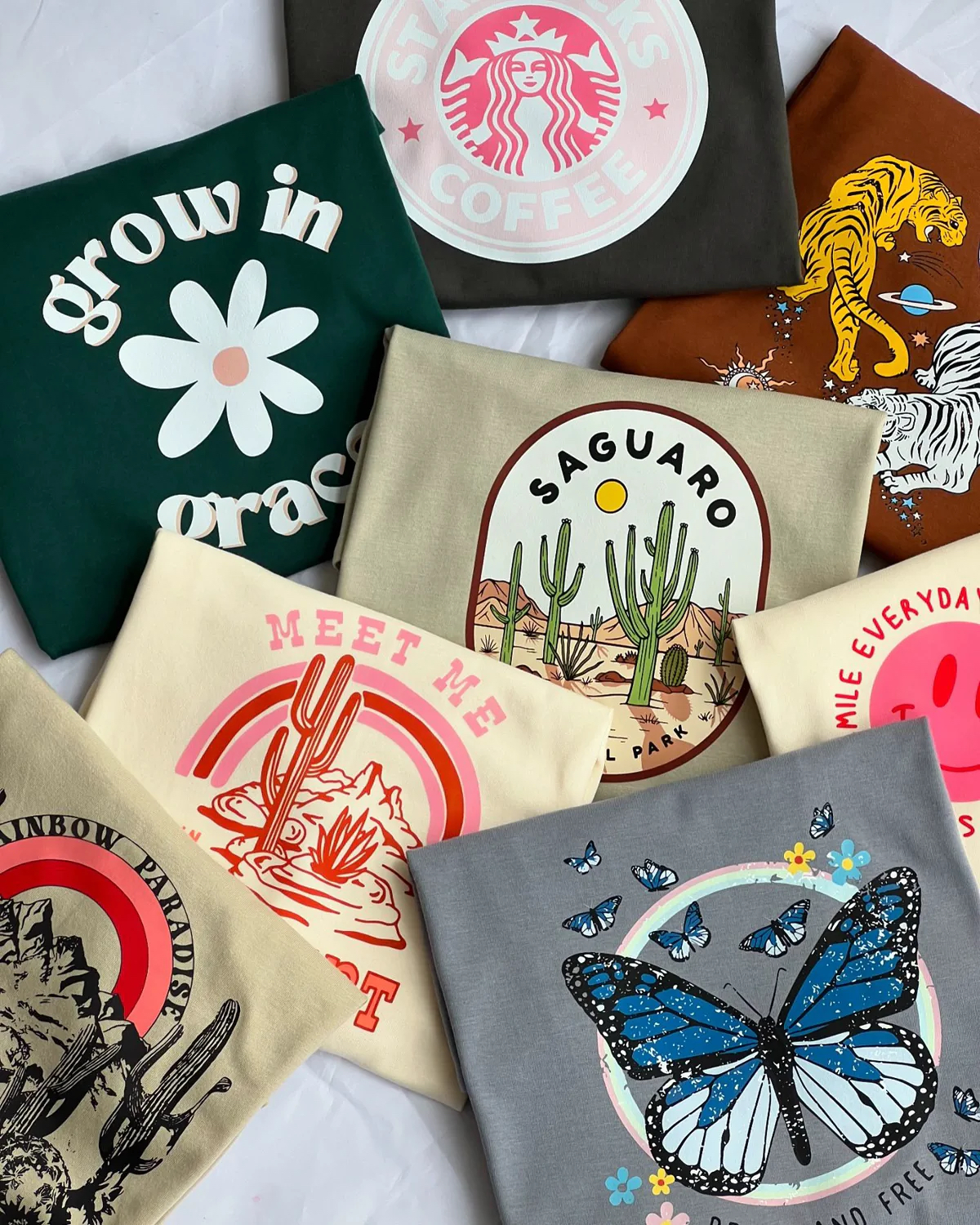 Stack of folded custom printed t-shirts with retro graphic designs